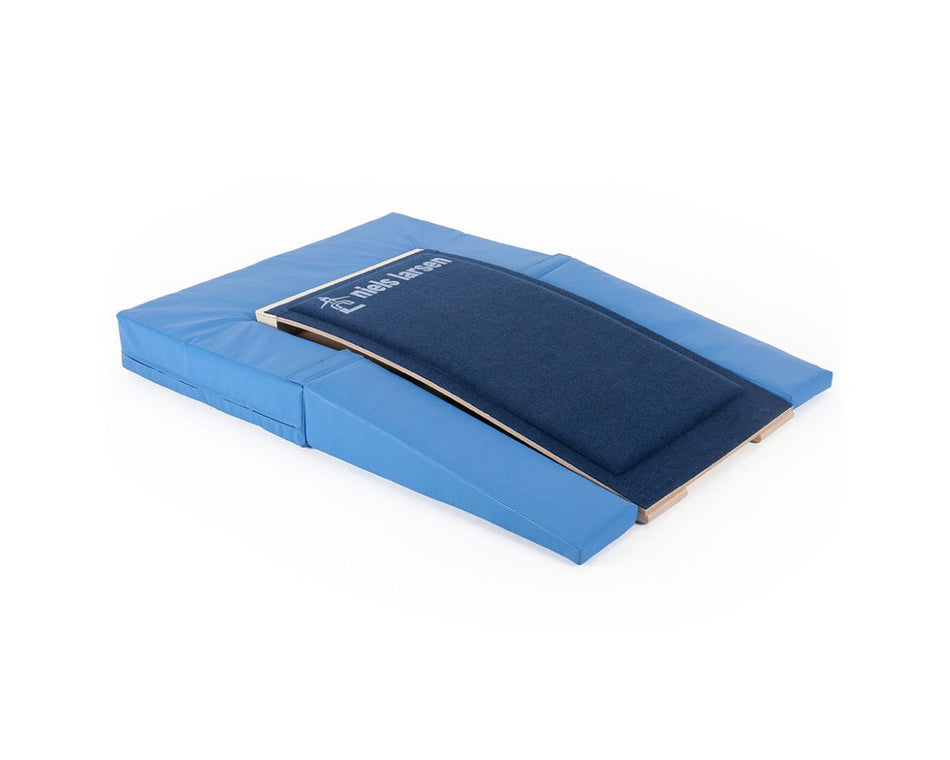 The Niels Larsen Springboard Full Surround for LRE020 is a blue gymnastics mat with a foam interior, raised carpeted ramp, and padded sides, designed by Niels Larsen for training and skill development.