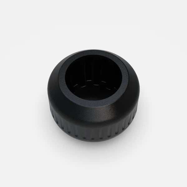 The nub - Black by nub Sports is a black, round, ridged socket tool with a hexagonal interior—perfect for cricket bat handle attachments or grip upgrades—shown from above on a plain white background.