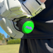 Wearing white sports gloves, a person grips a bat with a bright green nub - Green Thunder end cap by nub Sports and a silicone bat grip, standing outdoors on grass under sunny skies.