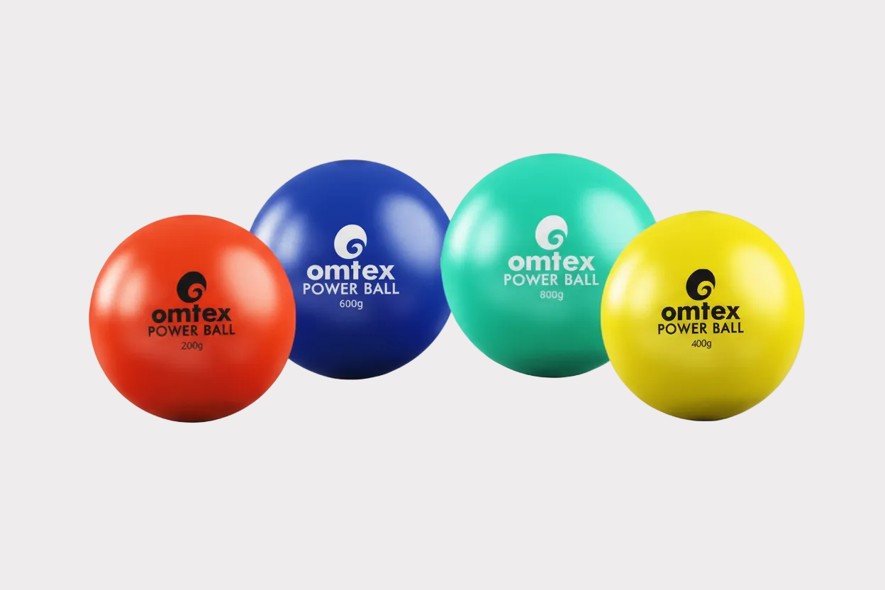 Four Omtex PowerBall weighted cricket balls in red, blue, green, and yellow are arranged in a row on a white background. Each ball shows its weight and the Omtex logo—ideal for improving batting skills during cricket training.