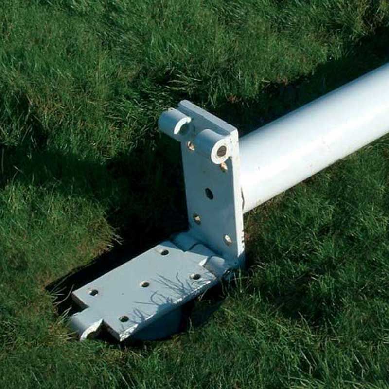 A white metal pole with a bolted base mount lies horizontally on green grass, partially inserted into a ground sleeve—demonstrating the use of Harrod Sport Aluminium Rugby Post Hinge Adaptors, which allow for easier installation and erection of aluminium rugby posts.