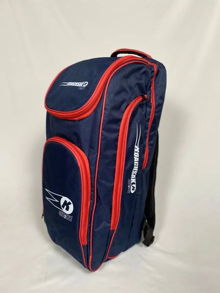 The Katchet KoachSak One2One is a navy/red cricket coach bag with multiple zippered compartments and white Katchet logos, ideal for one-to-one coaching, shown standing upright against a plain white background.