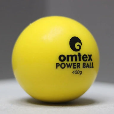 A bright yellow Omtex PowerBall weighted cricket ball with black "Omtex POWER BALL 400g" text is placed on a smooth, light surface, perfect for cricket training and improving batting power.