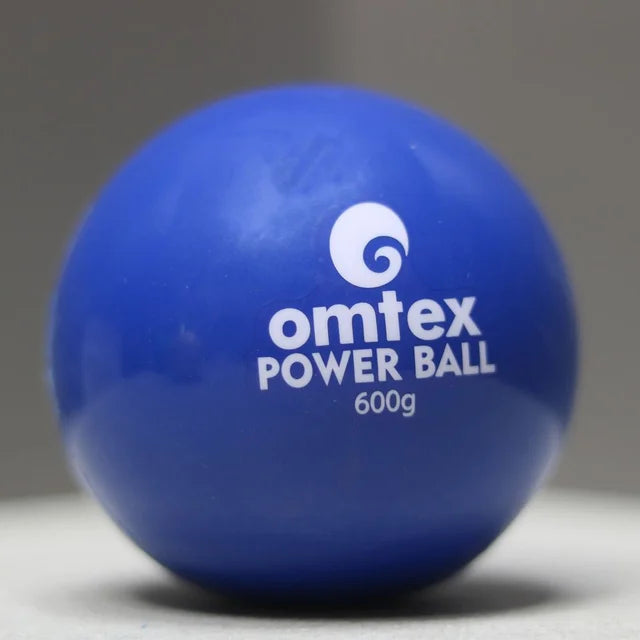 A blue Omtex PowerBall 600g for cricket training with weighted balls rests on a light surface against a gray background.