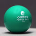 An Omtex PowerBall, a green weighted cricket ball by Omtex for training and boosting batting power, is placed on a light surface against a dark background.