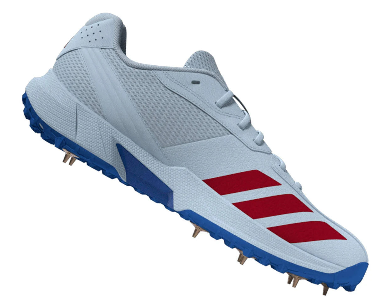 The Adidas 22YDS White/Red/Royal Cricket Spikes 2026 in Crystal Sky/Pure Ruby/Bright Royal feature mesh panels, a textured midsole, and metal spikes—ideal for cricket and track sports.
