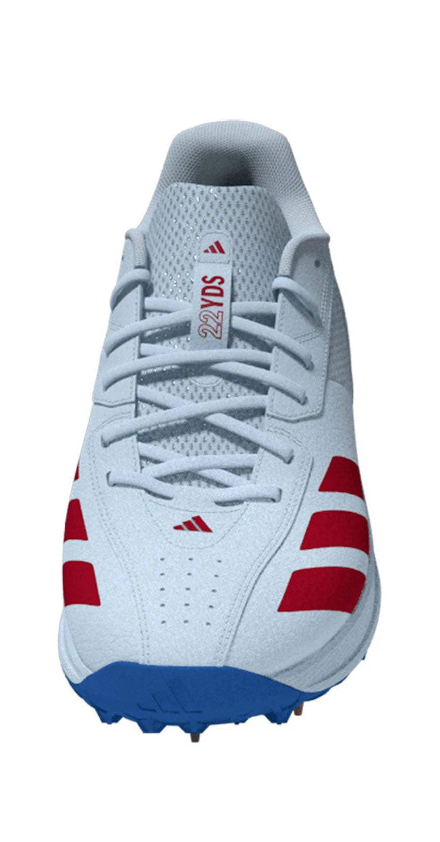A front-facing view of the Adidas 22YDS White/Red/Royal Cricket Spikes 2026—a light grey cricket shoe with red side stripes, a blue sole, and "22YDS" on the tongue—ideal for fans of Adidas cricket shoes.
