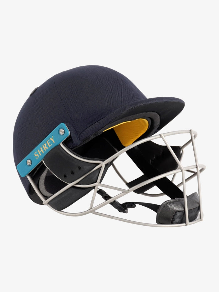 The Shrey Masterclass Air 2.0 Stainless Steel Helmet in dark blue features a stainless steel faceguard, black padding with yellow lining, advanced airflow system, and a blue SHREY side label with gold text on a white background.
