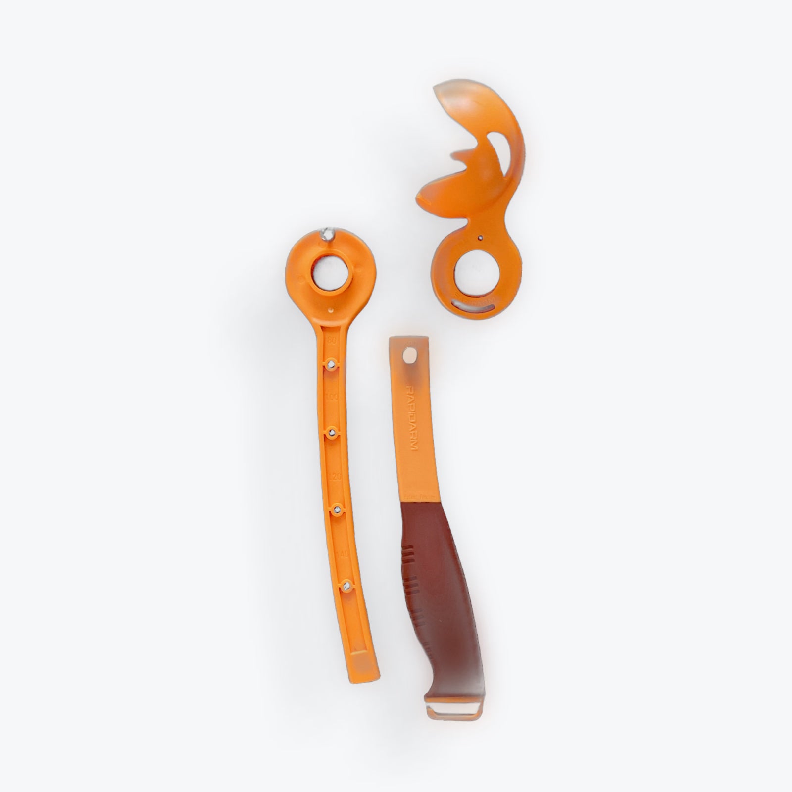 This set includes three orange plastic cricket training tools: a long flat handle with metal studs, a curved tool with cut-outs, and the RapidArm+ Ball Thrower by RapidArm featuring a wide base, brown grip, and rectangular opening.