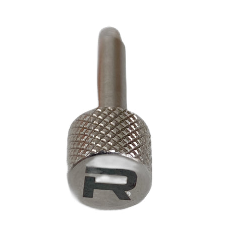 A close-up of the RapidArm+ Ball Thrower by RapidArm, featuring a metallic knurled grip and an engraved "R" on the end, photographed against a white background.