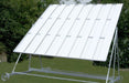 The Twenty/20 Sight Screen by Martin Berrill Sports is a large, white outdoor cricket sight screen with evenly spaced slats, a weather-resistant wheeled frame, and is set on grass with green trees behind it.