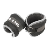 The Fitness Mad Wrist/Ankle Weights by Fitness Mad are black and gray neoprene weights (0.5KG each) with Velcro straps and metal D-rings, ideal for adding resistance to aerobic workouts.
