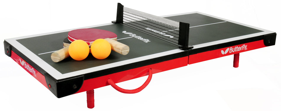 The Butterfly Mini Table Tennis Table set includes a black and red frame, a net, two wooden paddles with red rubber, and two orange balls. The Butterfly brand name is visible on the table.