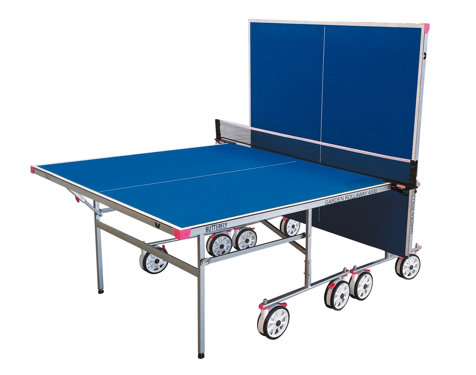 The Butterfly Garden Rollaway 4000 4mm Outdoor Table Tennis Table features a blue top, metal legs, solo play option with one half upright, white and pink trim, transport wheels, and a net dividing the surface.