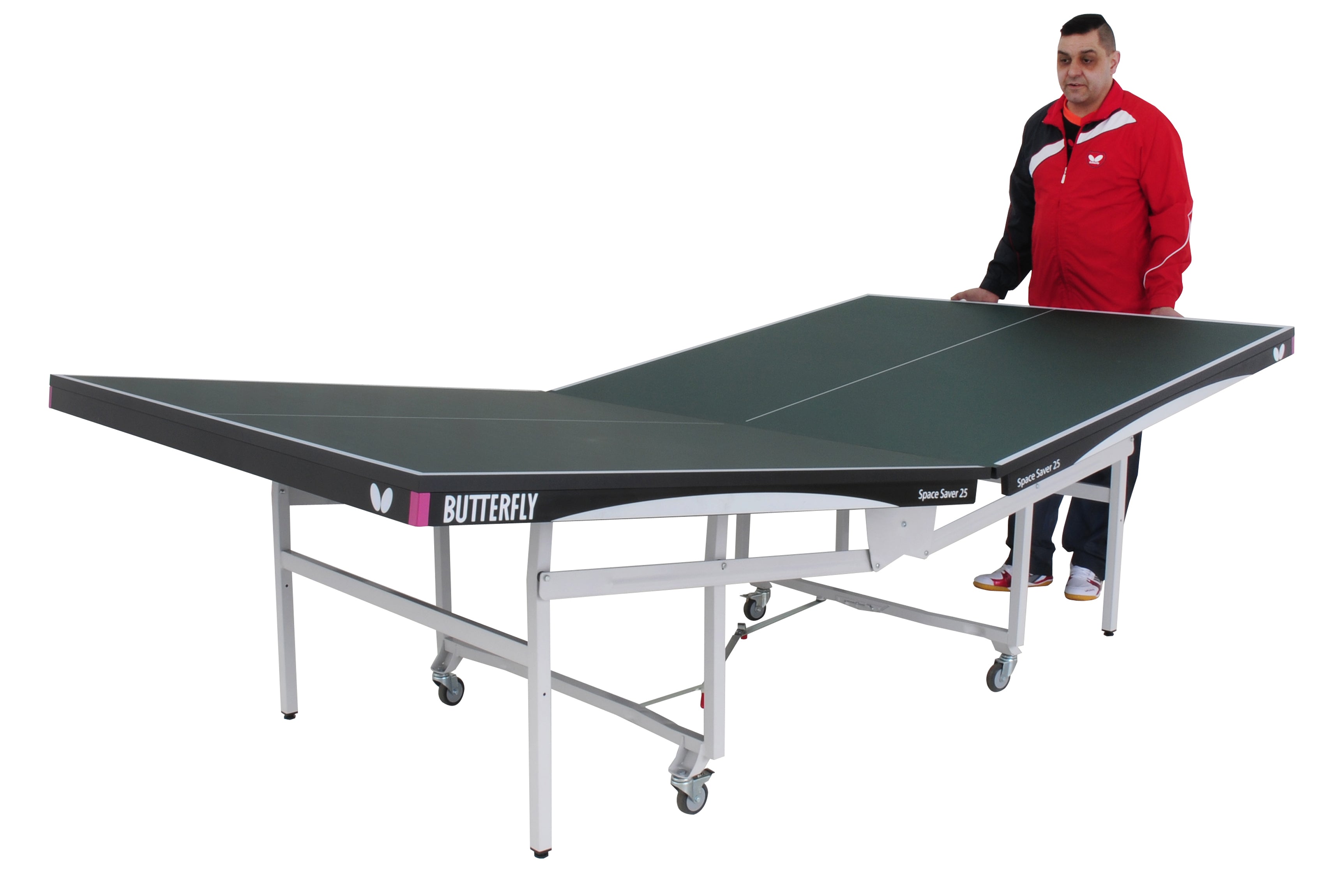 A man in a red and black jacket stands next to a green Butterfly Space Saver 22 Rollaway Table Tennis Table, which has one half upright for solo play or storage and is wheelchair-friendly.