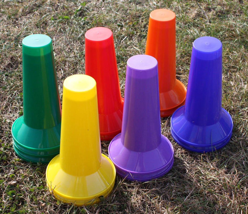 The Martin Berrill Sports Training Cones - Set of 8 features vibrant cones arranged upright on dry grass, ideal coaching equipment for training sessions.