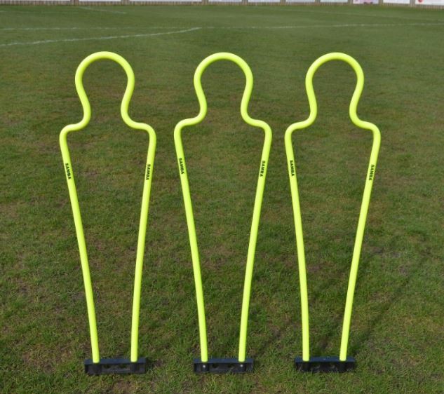 Three Samba Sports Pep Pro Junior Mannequins (set of 3, with carry bag) stand upright on a grassy soccer field, ideal for free kick practice and football training drills.