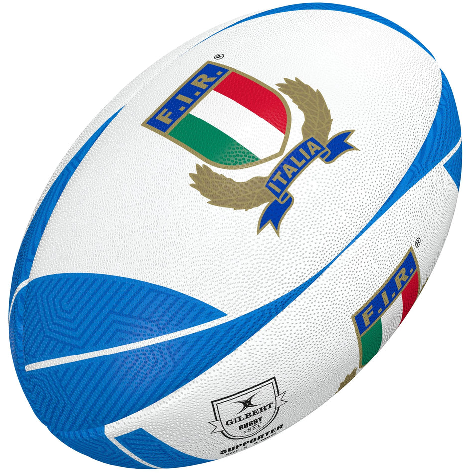 The Gilbert Italy Supporter Rugby Ball by Gilbert is white and blue, featuring the Italian Rugby Federation (F.I.R.) logo with a tricolor shield and "Italia" on a blue banner—perfect memorabilia for fans, with the manufacturer's logo also displayed.