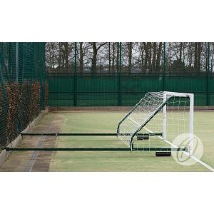 A Harrod Sport 4G Fence Folding Goal (3.66m x 1.22m, 2.3m to 3.5m projection) is placed sideways against a fence on an outdoor field, with trees and a green mesh fence visible in the background.