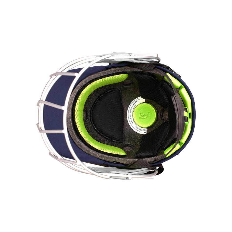 Top view of the Kookaburra Pro 1500 Junior Helmet by Kookaburra, featuring green and black padding, a white central adjustment knob, blue outer shell, and a white titanium faceguard.