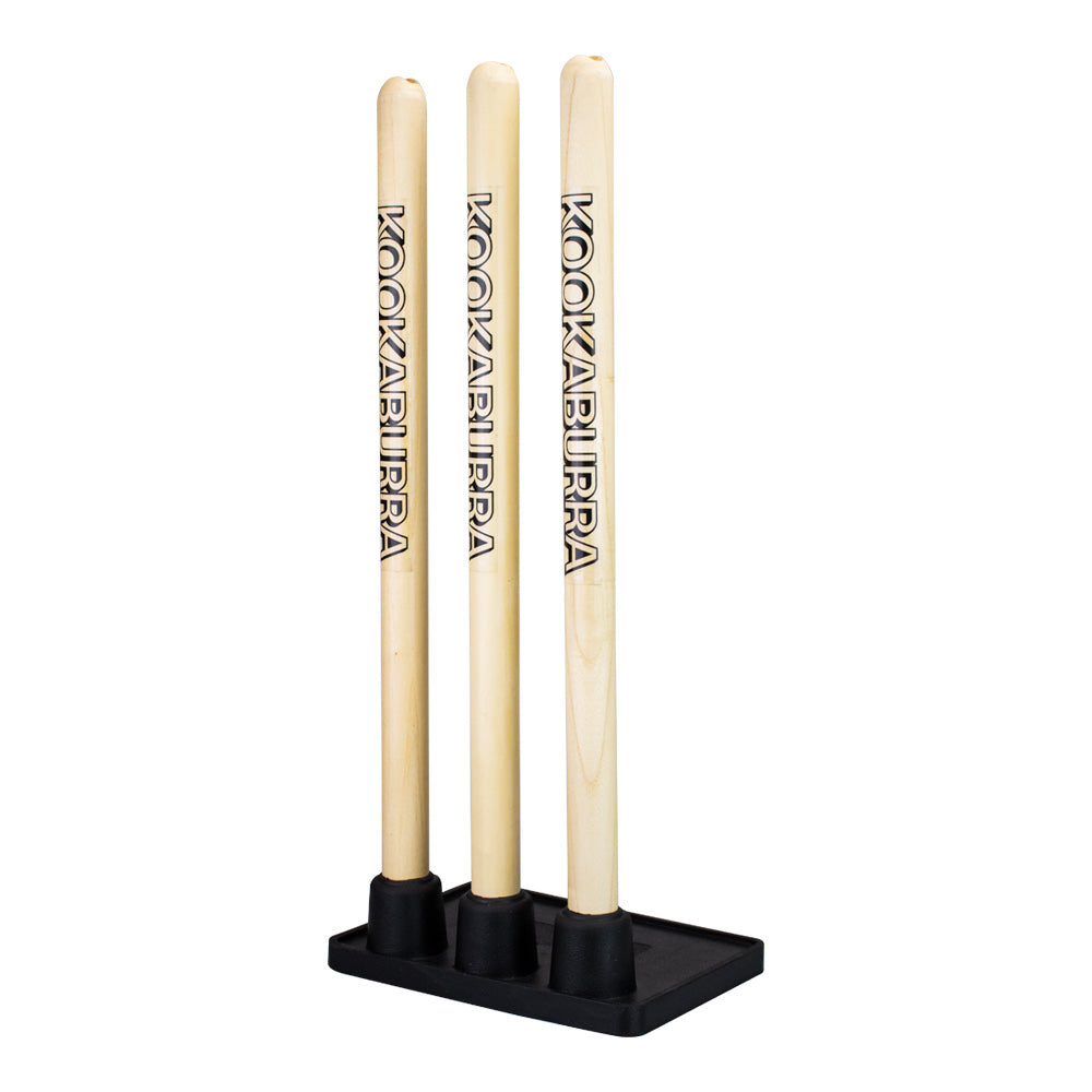 Kookaburra Wooden Practice Stumps: three light wooden stumps with KOOKABURRA branding, each in a black rubber base on a rectangular platform—perfect as replacement stumps for your cricket set.