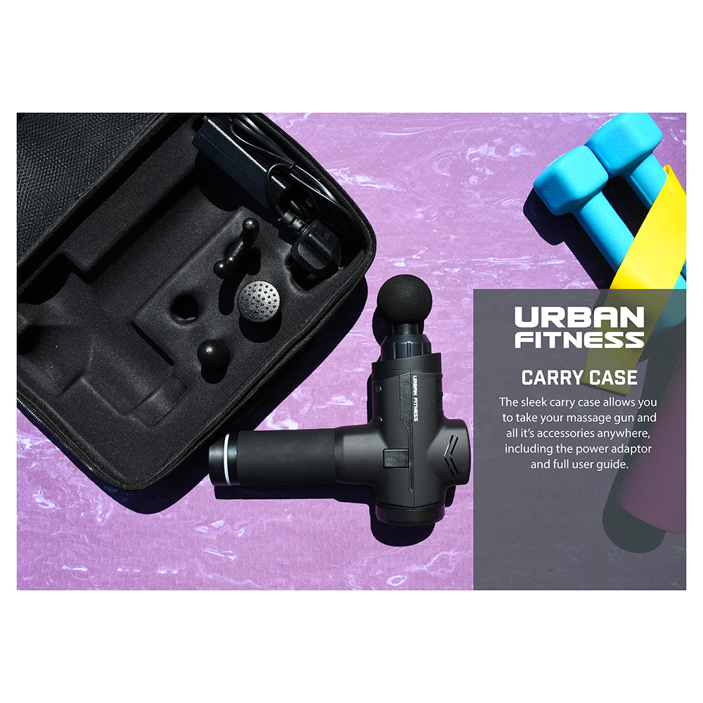 The Urban Fitness Massage Gun with attachments and carry case is displayed on a purple surface, alongside two blue dumbbells and a yellow strap. Text: Urban Fitness Carry Case.