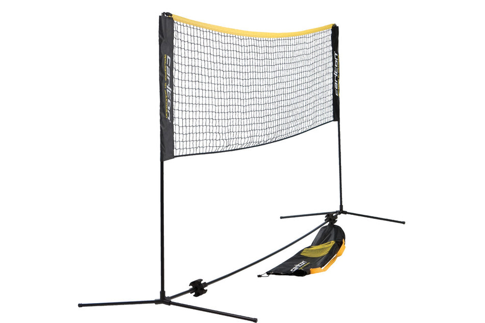 The Carlton Badminton Put Up Net & Post Set features a portable, height-adjustable net with black poles, a black and yellow top edge, flat base legs for elevation, and a black carrying bag attached to one pole.