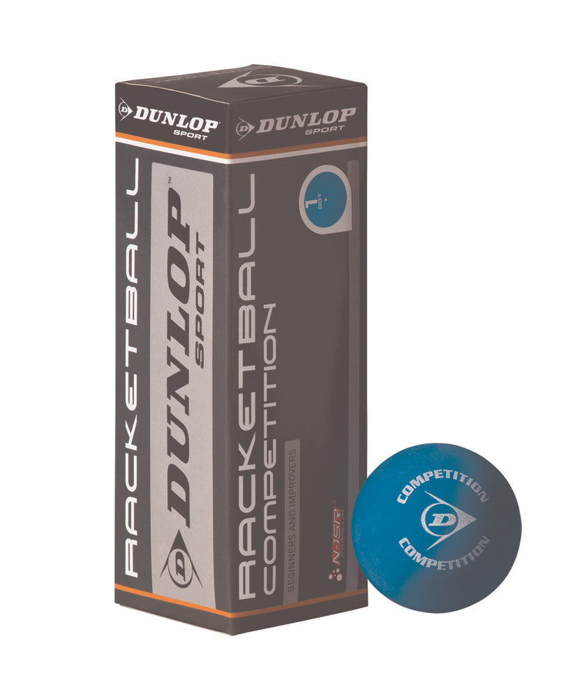 A Dunlop Competition 3 Ball Box stands upright next to a blue racquetball with “Competition” and the Dunlop logo. The brown and gray packaging features white and orange accents.