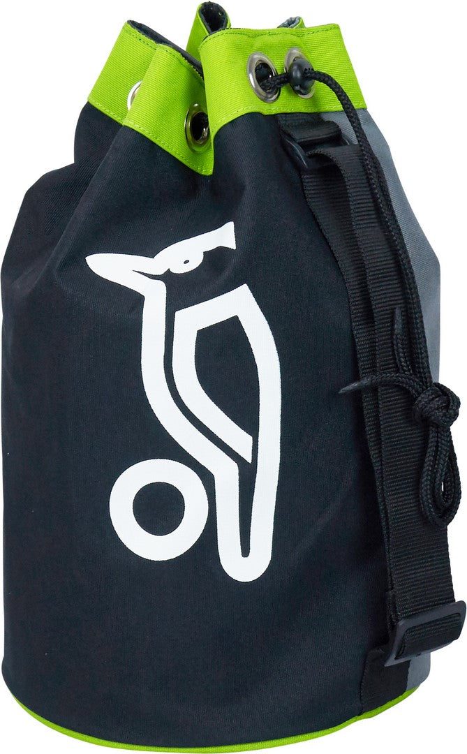 The Kookaburra KT 100 Training Bag is a black and green cylindrical net practice bag with a white bird logo, made from braided 600D material. It has metal eyelets and an adjustable shoulder strap for easy carrying.
