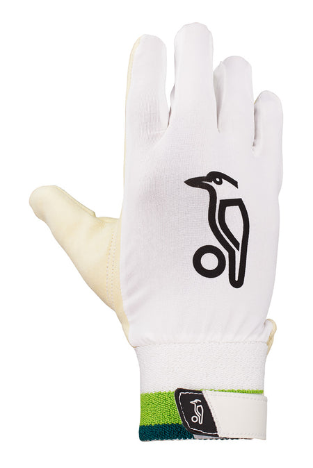 The Kookaburra Ultimate Wicket Keeping Inner is a single white glove with a black bird logo, ergonomic memory foam, and a green-blue wrist strap. The Velcro closure also features the Kookaburra brand logo. Glove shown palm down.