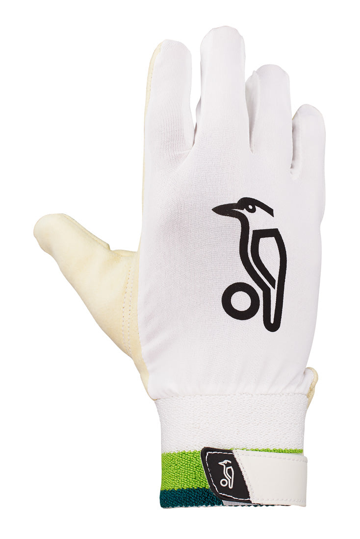 The Kookaburra Ultimate Wicket Keeping Inner is a single white glove with a black bird logo, ergonomic memory foam, and a green-blue wrist strap. The Velcro closure also features the Kookaburra brand logo. Glove shown palm down.
