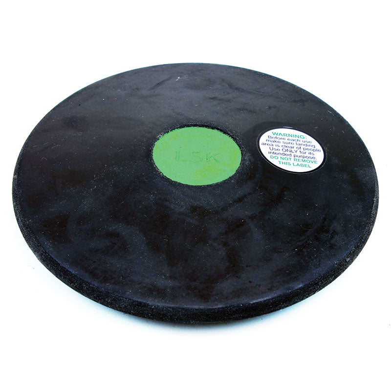 The Mastersport Rubber Training Discus features a black rubber body, green center marked "1.5K," and white warning sticker. Durable and reliable, it’s perfect for track and field practice sessions.