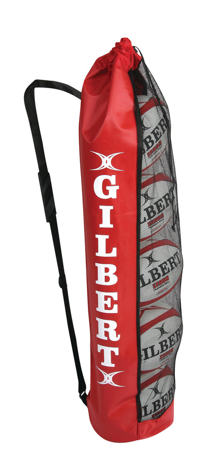 The Gilbert Rugby Ball Tube (5 Ball Bag) by Gilbert is a red mesh sports bag with a shoulder strap, ideal for carrying up to five rugby balls to training sessions. It features the GILBERT logo in large white letters and suits storing white rugby balls with black markings.