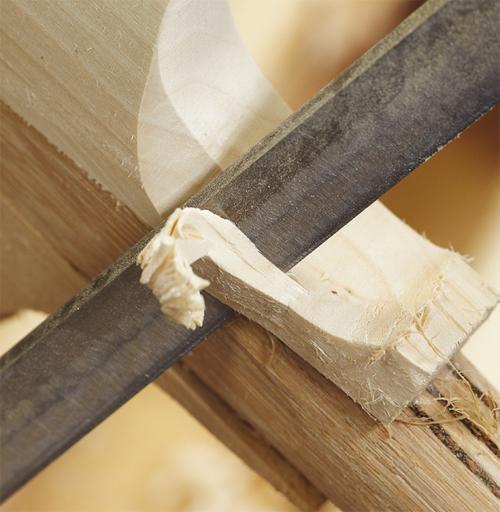 Close-up of a metal hand file smoothing the surface of a Martin Berrill Sports Custom Made Cricket Bat (Grade 4 Willow), creating a thin wood shaving.