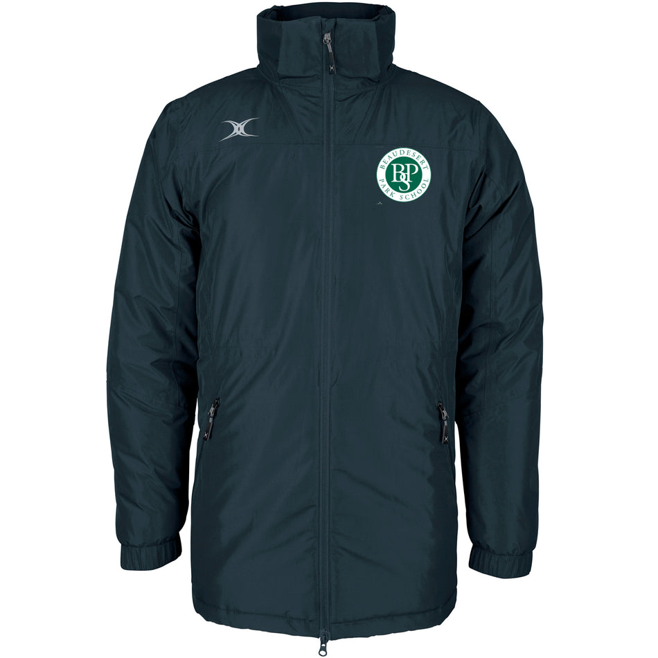 The Gilbert Beaudesert Park School Pro All-Weather Jacket is a long, dark green padded coat with a high collar, zip front, and two zip pockets. It features the school’s circular crest on the left chest and a white logo on the right shoulder.
