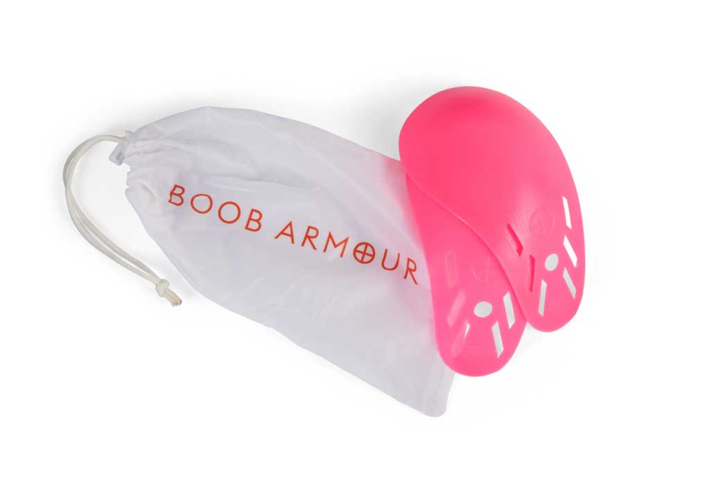 A pair of pink Boob Armour Inserts from Boob Armour are shown next to a white drawstring bag with the brand name in orange.