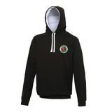The Martin Berrill Sports Burwash CC Black/White Hoodie features white drawstrings, a double fabric hood lined in light gray, a kangaroo pouch pocket, and a small circular green and red emblem on the upper left chest.