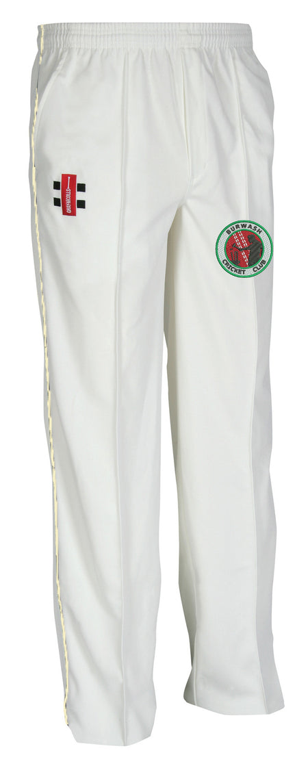 The Gray Nicolls Burwash CC Junior Matrix V2 Cricket Trouser features an elastic waistband, ergonomic design for comfort and moisture control, a red/black thigh patch, and a circular green/black/red team logo on the other leg.