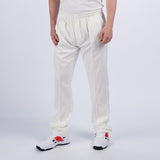 A person in Gray Nicolls Penallt & Redbrook CC Matrix V2 Cricket Trousers, a matching shirt, and white sports shoes with red and black accents stands against a plain light background. Image is cropped below the shoulders.