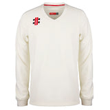 The Gray Nicolls Pro Performance Senior Sweater is an ivory, long-sleeved V-neck cricket sweater featuring subtle red and black Gray Nicolls logo patches on the left chest and inner collar.