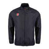 The Gray Nicolls Velocity Rain Jacket is a black, lightweight, water-repellent zip-up with a high collar and long sleeves. It features a small red and white rectangular logo on the left chest—ideal for staying dry at cricket matches.