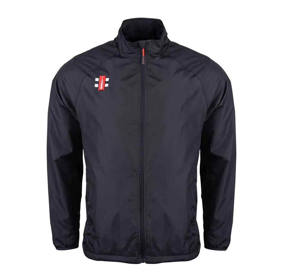 The Gray Nicolls Rockhampton CC Velocity Rain Jacket - Senior is black with a high collar, long sleeves, side pockets, and a water-repellent finish. A small red and white rectangular logo appears on the left chest. The background is plain white.