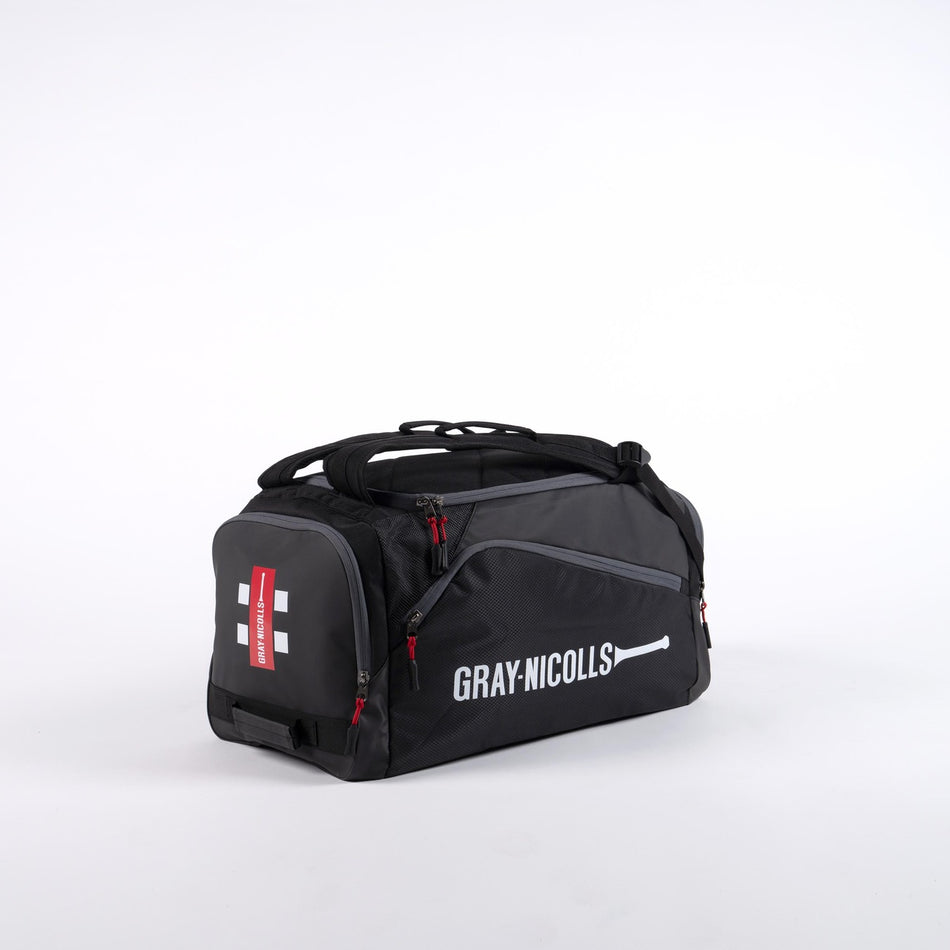The Gray Nicolls Team Holdall 2026 is a black match day bag with red zippers, a side shoe pocket, and a white Gray Nicolls logo with cricket bat icon on the main side, displayed against a plain white background.