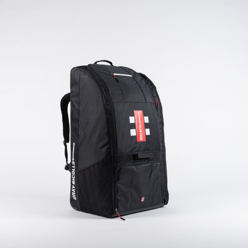 The Gray Nicolls Coach Bag 2026 is a large black sports backpack with red accents and the Gray Nicolls logo, featuring multiple compartments and zippers for all your coaching essentials. Shown on a white background.