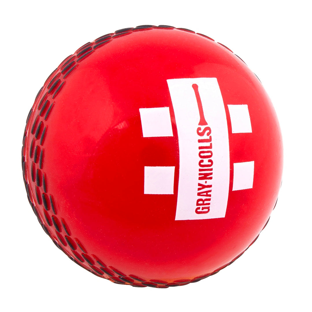 The Gray Nicolls PowerPlay Ball is a red cricket ball with black stitching, ideal for soft-ball cricket. It features a white rectangular GRAY-NICOLLS logo in red and two white square marks on either side.
