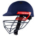 The Gray Nicolls Junior Ultimate Helmet in navy blue features a metal face guard, red side logo, and adjustable chin strap for a secure, comfortable fit.