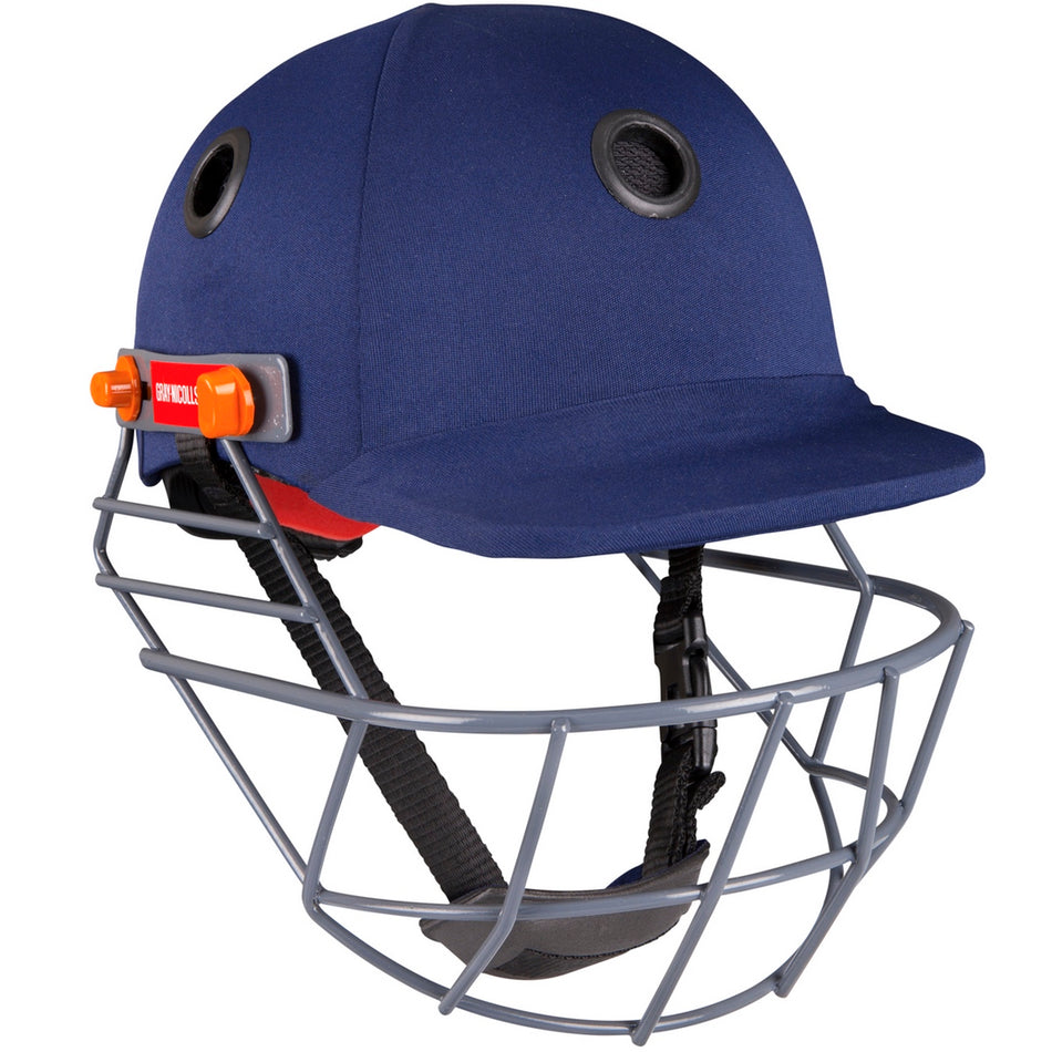 The Gray Nicolls Elite Junior Helmet in navy, featuring a face guard, ventilation holes, adjustable chin strap, and orange side clips, is shown against a white background.