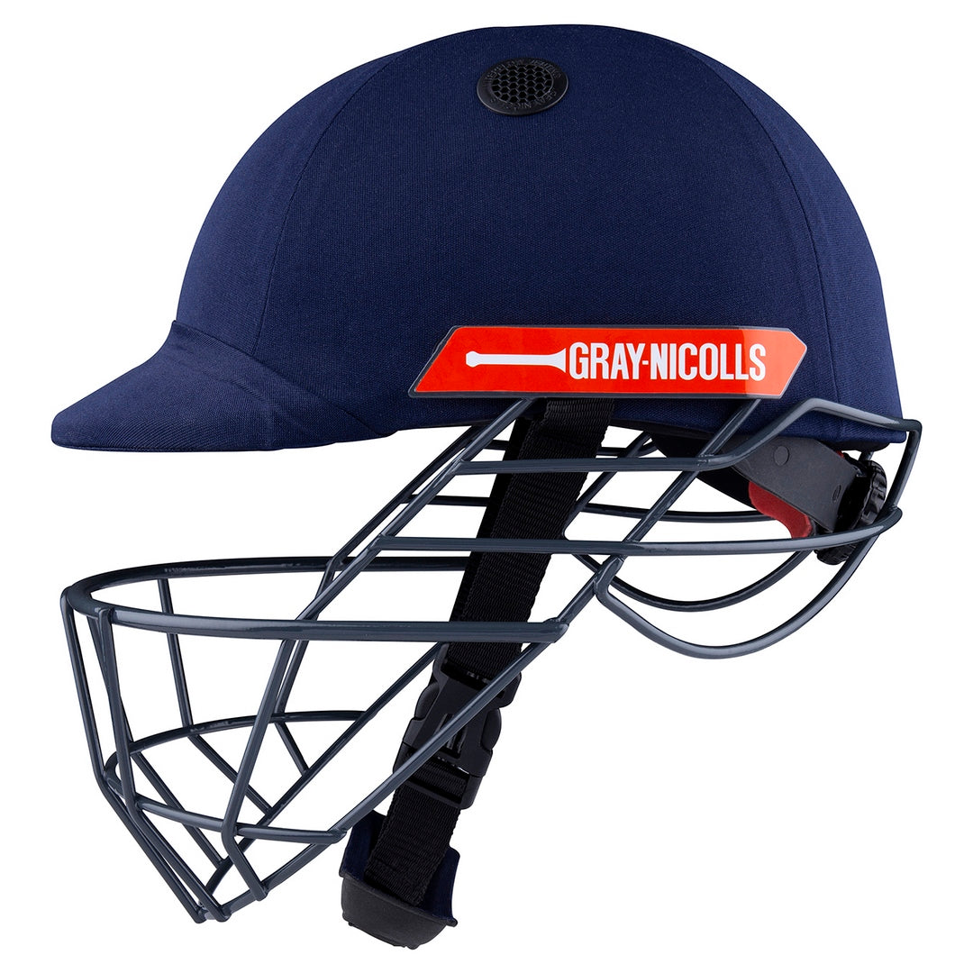 The Gray Nicolls Atomic 360 Helmet in navy blue features a metal face guard, black chin strap, and red side label—ideal protective gear for cricket players.