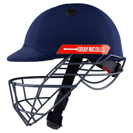 The Gray Nicolls Atomic 360 Helmet in navy blue features a metal face guard, black chin strap, and red side label—ideal protective gear for cricket players.