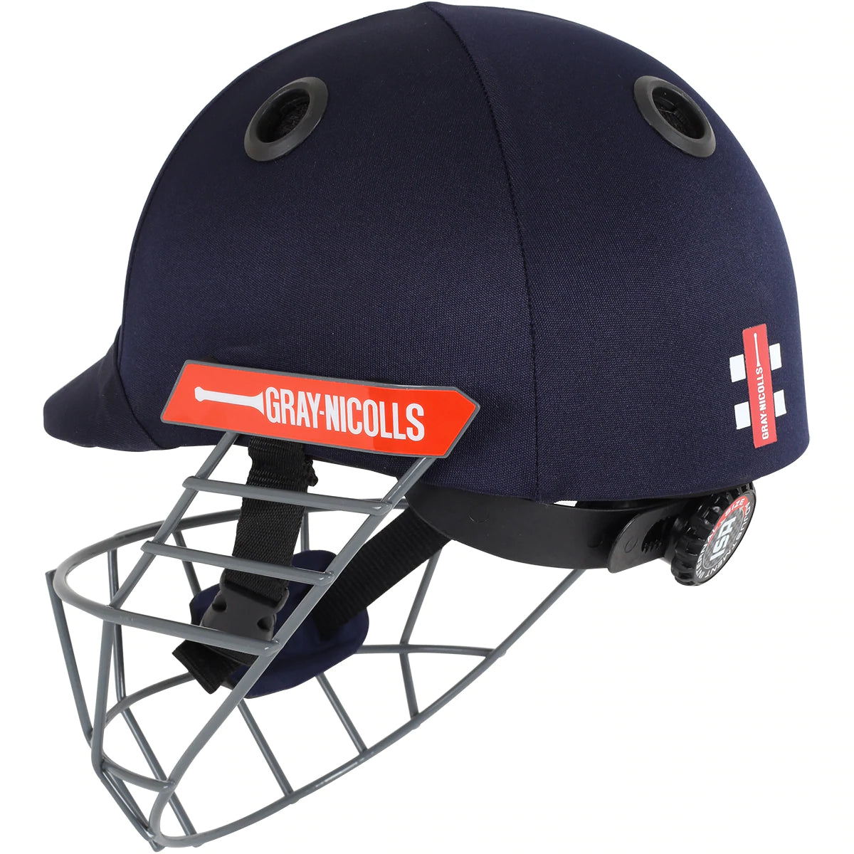The Gray Nicolls Atomic Helmet is a lightweight junior cricket helmet in navy blue, featuring a metal faceguard, black ventilation holes, red side logo, and an adjustable back strap for a secure fit.